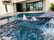 Inviting pool with integrated spa and water features surrounded by an entertainment area with patio seating at 2110 Michele Dr, Sarasota, FL 34231