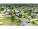 Real estate listing image showcases neighborhood featuring houses, green lawns and mature trees at 23136 Langdon Ave, Port Charlotte, FL 33954