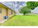 Well-maintained backyard with lush green grass, mature trees, and a privacy fence, perfect for outdoor activities at 23136 Langdon Ave, Port Charlotte, FL 33954
