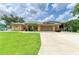 Beautiful single-Gathering home showcases lush green lawn, solar panels, and an extended covered driveway at 23136 Langdon Ave, Port Charlotte, FL 33954