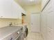 Well-equipped laundry room with washer, dryer, storage cabinets, and closet at 23136 Langdon Ave, Port Charlotte, FL 33954