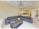 Spacious living room featuring a large comfortable sofa, a ceiling fan and recessed lighting at 23136 Langdon Ave, Port Charlotte, FL 33954