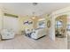 Open concept living room with tile floors, light yellow walls, and white furniture at 23136 Langdon Ave, Port Charlotte, FL 33954