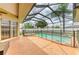 Screened-in pool and hot tub with brick patio and fenced surround at 23136 Langdon Ave, Port Charlotte, FL 33954