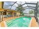 Screened-in pool and spa area, patio furniture, and serene backyard views at 23136 Langdon Ave, Port Charlotte, FL 33954