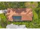 Aerial view of terracotta tile roof, screened in pool, and lush landscaping at 2518 Dick Wilson Dr, Sarasota, FL 34240