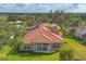 Back of house featuring a tiled roof, manicured lawn, and rear sunroom at 2518 Dick Wilson Dr, Sarasota, FL 34240