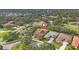 Aerial view of a single-story home with solar panels and a tile roof in a lush neighborhood at 2518 Dick Wilson Dr, Sarasota, FL 34240