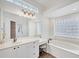 Bright primary bathroom with dual sinks, a large mirror, lots of cabinet space, a soaking tub, and a separate shower at 2518 Dick Wilson Dr, Sarasota, FL 34240