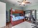Charming bedroom with bunk bed, ceiling fan, hardwood floors, and custom shelving units at 2518 Dick Wilson Dr, Sarasota, FL 34240