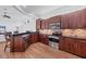 Well-lit kitchen with dark wood cabinets, granite countertops, and stainless steel appliances at 2518 Dick Wilson Dr, Sarasota, FL 34240