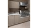 This kitchen features an indoor gas grill, neutral cabinetry, and white countertops at 2518 Dick Wilson Dr, Sarasota, FL 34240