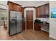 Well lit kitchen shows stainless steel refrigerator and dark brown wood cabinets at 2518 Dick Wilson Dr, Sarasota, FL 34240