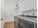 Well-lit laundry room featuring white cabinetry, modern washer and dryer, and vinyl wood flooring at 2518 Dick Wilson Dr, Sarasota, FL 34240