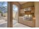 Outdoor kitchen with stainless steel grill, sink, and storage, with a view of the lanai at 2518 Dick Wilson Dr, Sarasota, FL 34240