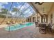 Enclosed pool features a hot tub, lounge chairs, and an outdoor dining area at 2518 Dick Wilson Dr, Sarasota, FL 34240