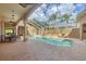 Enclosed pool and spa with brick patio, outdoor seating, and a large, covered lanai at 2518 Dick Wilson Dr, Sarasota, FL 34240