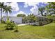 Lush backyard with a screened-in pool area, tropical plants and well-maintained lawn at 3167 Pinetree St, Port Charlotte, FL 33952