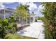 A view of the pool area showing lush landscaping, a tile patio, and backyard at 3167 Pinetree St, Port Charlotte, FL 33952