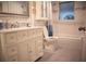 This bathroom features a white vanity with ample storage and a tub with tiled walls at 3167 Pinetree St, Port Charlotte, FL 33952