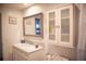 Bathroom vanity features a grey framed mirror and cabinet and mosaic tile backsplash at 3167 Pinetree St, Port Charlotte, FL 33952