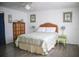 This bedroom boasts a queen bed with wicker headboard, tropical decor, and wood-look flooring at 3167 Pinetree St, Port Charlotte, FL 33952