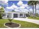 Beautiful home with a well-manicured lawn, driveway, mature trees, and attached garage at 3167 Pinetree St, Port Charlotte, FL 33952