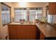 The kitchen features warm wood cabinetry, granite counters, and a stainless steel sink at 3167 Pinetree St, Port Charlotte, FL 33952