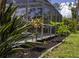 Screened-in pool area features lush landscaping surrounding the perimeter at 3167 Pinetree St, Port Charlotte, FL 33952