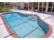 Relax in this kidney shaped screened in pool with brick trim and seating at 3167 Pinetree St, Port Charlotte, FL 33952