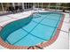 Relax in this kidney shaped screened in pool with brick trim and seating at 3167 Pinetree St, Port Charlotte, FL 33952