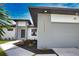 Modern home featuring a gray garage door, manicured landscaping, and stylish exterior lighting at 350 Bucknell Rd, Venice, FL 34293