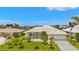 Well-maintained single-story home with lush landscaping, a white tile roof, and an attached two-car garage at 3615 Tripoli Blvd, Punta Gorda, FL 33950