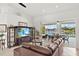 Living room with modern entertainment center and sliding glass doors leading to a lanai with a pool view at 3615 Tripoli Blvd, Punta Gorda, FL 33950
