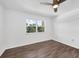 Bedroom with wood floors, ceiling fan, and a window overlooking trees at 3640 Ironwood Cir # 302N, Bradenton, FL 34209