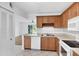Bright kitchen features wood cabinets, white appliances, and tile flooring with views of the living area at 3640 Ironwood Cir # 302N, Bradenton, FL 34209