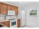 Bright kitchen features wood cabinets, white appliances, and natural light at 3640 Ironwood Cir # 302N, Bradenton, FL 34209