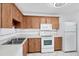 Bright kitchen features wood cabinets, white appliances, and tile flooring at 3640 Ironwood Cir # 302N, Bradenton, FL 34209