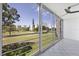 Enclosed lanai with tiled floors and a view of the golf course and nearby buildings at 3640 Ironwood Cir # 302N, Bradenton, FL 34209