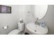 Powder room featuring a white sink and toilet, an oval mirror, and a framed art piece at 3673 Fescue Ln, Sarasota, FL 34232