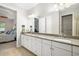 Bright bathroom featuring a double vanity with stone countertop and an open view to the bedroom at 3673 Fescue Ln, Sarasota, FL 34232