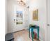 Bright foyer boasts wood-look tile, a stylish accent table and glass paneled front door at 3673 Fescue Ln, Sarasota, FL 34232