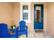 Cozy front porch with blue chairs and a 'hello' mat, offering a welcoming entrance to the home at 3673 Fescue Ln, Sarasota, FL 34232