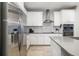 Modern kitchen with white cabinets, stainless steel appliances, and a stylish range hood at 3673 Fescue Ln, Sarasota, FL 34232