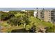 Scenic view of the condo complex with a verdant golf course, lake, and mature trees in the background at 3680 Ironwood Cir # 603L, Bradenton, FL 34209