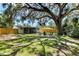 Spacious backyard with patio, fire pit, and mature trees and lush grass at 4041 Linwood St, Sarasota, FL 34232