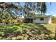 A sprawling backyard features a cozy fire pit, covered patio, wood fence, and lush green lawn at 4041 Linwood St, Sarasota, FL 34232