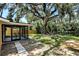 Large backyard with patio and fire pit under a mature, shady tree at 4041 Linwood St, Sarasota, FL 34232