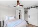 Comfortable bedroom with ceiling fan, barn door to closet and adjacent bathroom at 4041 Linwood St, Sarasota, FL 34232