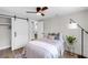 Relaxing bedroom with ceiling fan, sliding barn door to closet, and decorative lamp at 4041 Linwood St, Sarasota, FL 34232